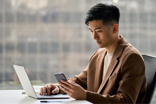 Geschäftsmann mit Laptop und Smartphone